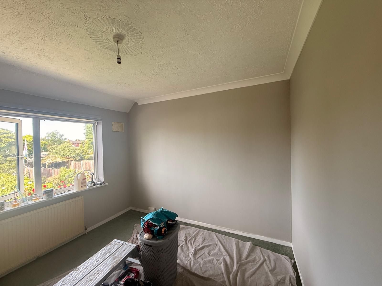 The same bedroom after redecoration in a fresh warm neutral